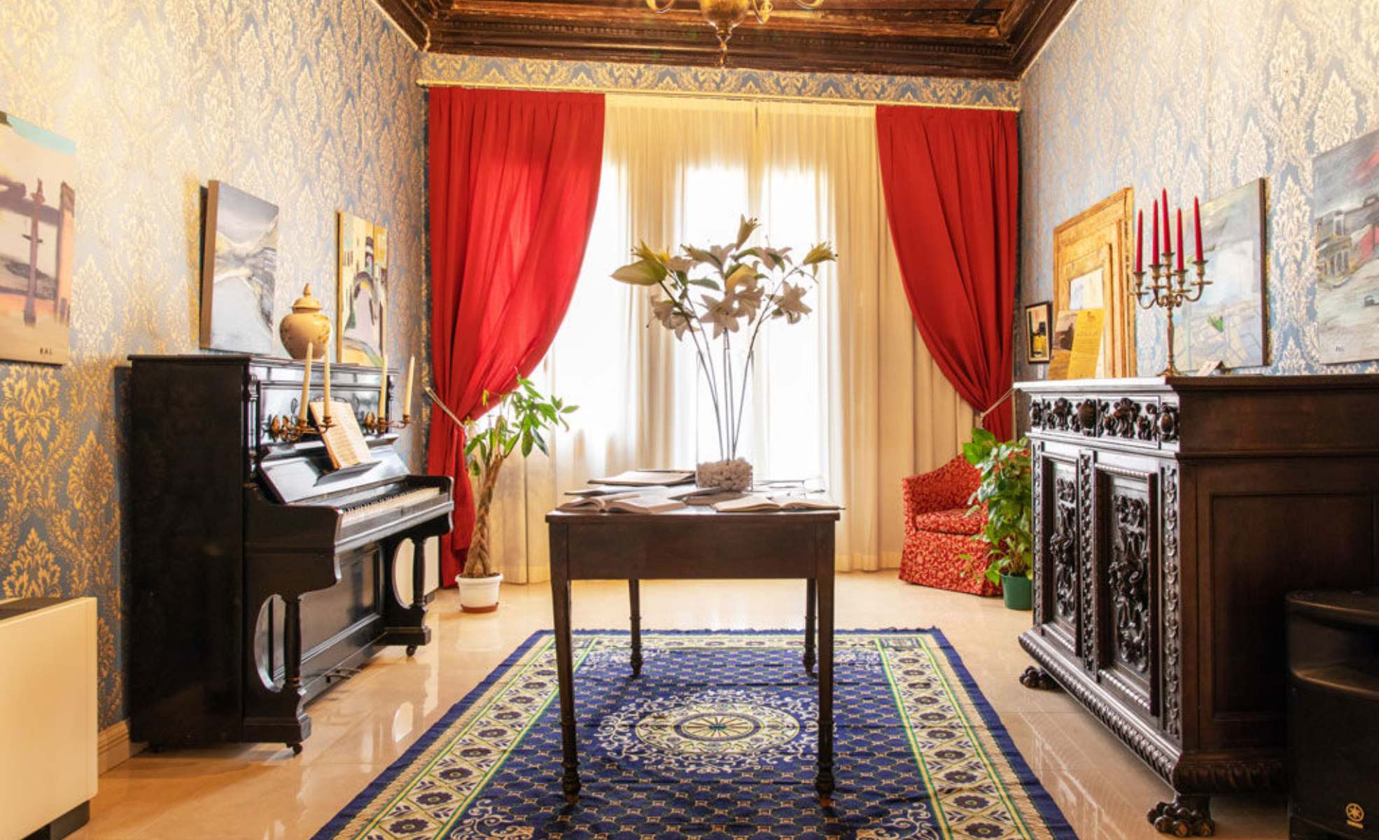Salotto comune del Palace con pianoforte e tende rosse